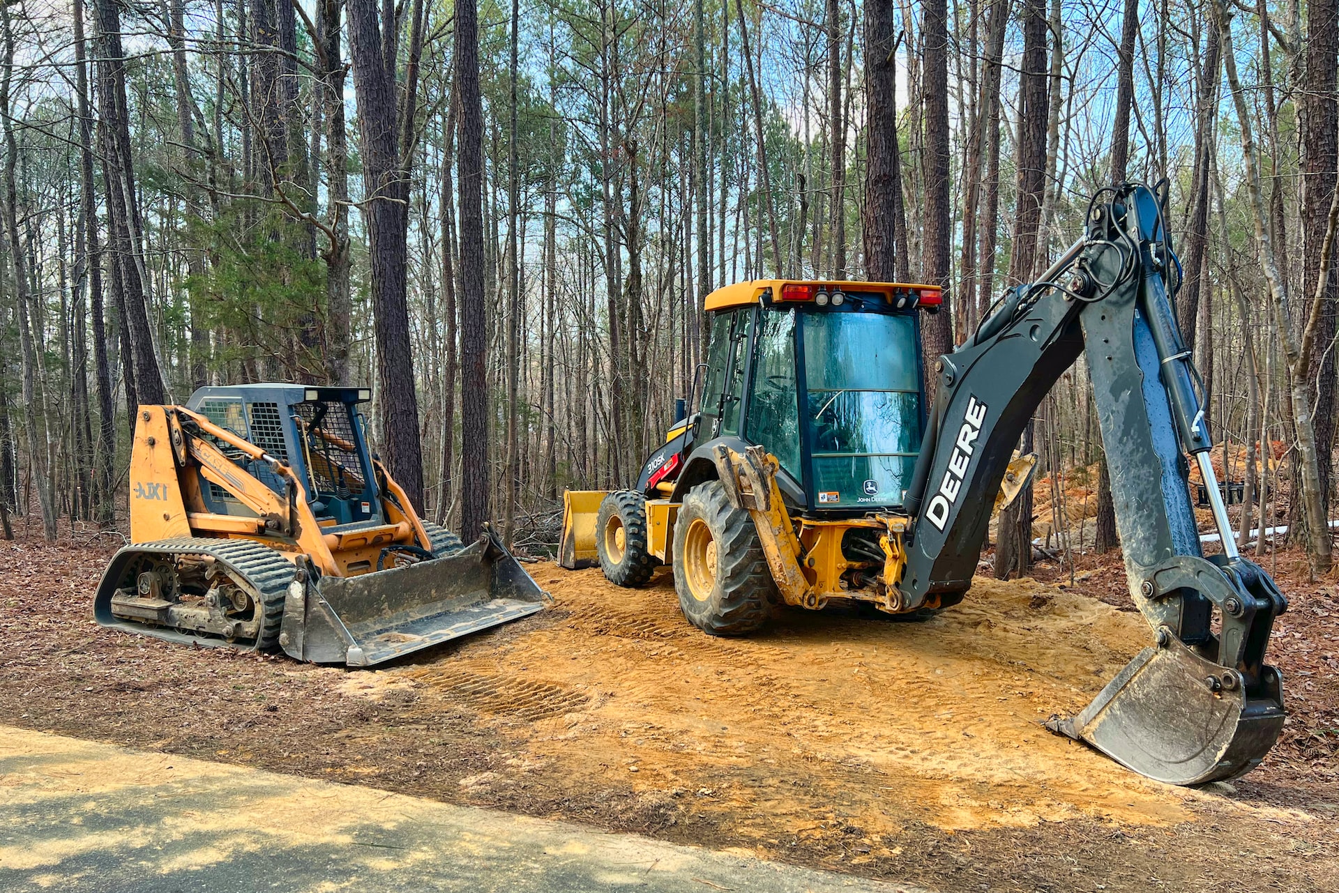 a tractor and a bulldozer are parked on a dirt road